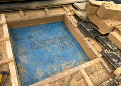 Ouverture du chevêtre dans la toiture on voit la découpe précise dans l’isolant en fibre de bois rigide 16 cm et la membrane d’étanchéité bleue mise à nu avant la pose de la fenêtre de toit